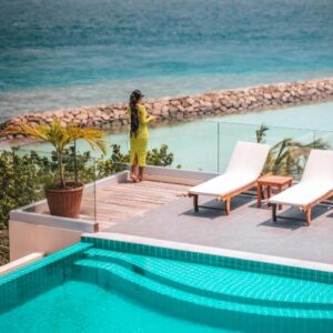 Pool and sun loungers on a terrace at Season Paradise, looking out over the lagoon
