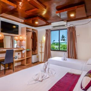 Guest room at Summer Villa Guest House with a double and a single bed under a timber ceiling